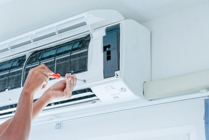 The technician under repairing the air conditioner | Pro Comfort Heating & Cooling
