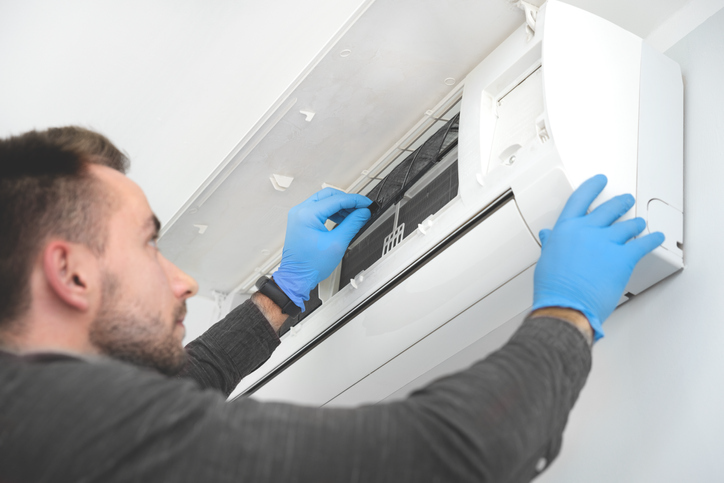 Technician repairing air conditioner | Pro Comfort Heating & Cooling