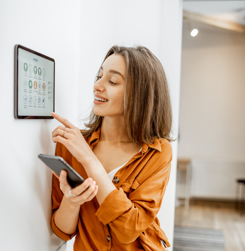 Female in front of thermostat | Pro Comfort Heating & Cooling