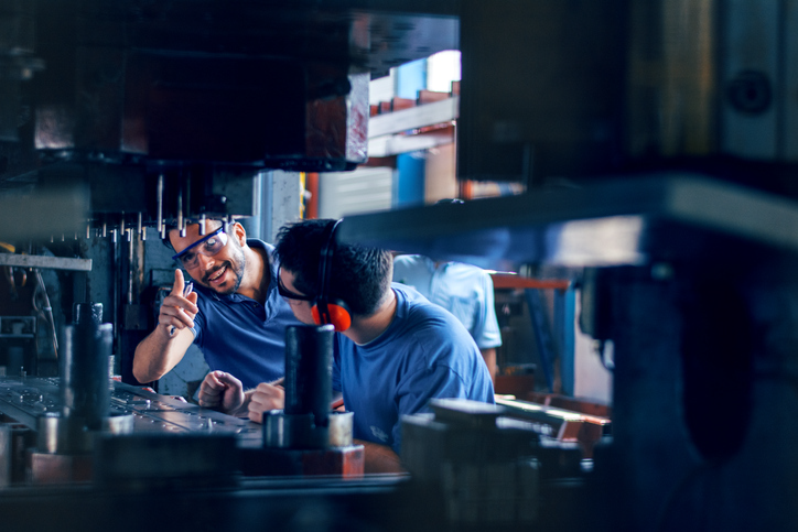 Workers working on the machine for cutting metal sheets | Pro Comfort Heating & Cooling