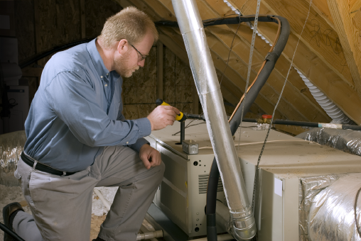 Technician inspecting furnace | Pro Comfort Heating & Cooling