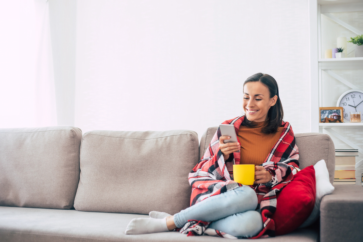 woman with a smartphone and cup in hands | Pro Comfort Heating & Cooling